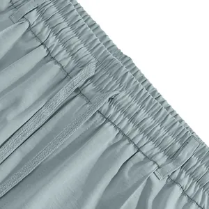 Close-up view of the elastic waistband with drawstring on men's light blue casual pants