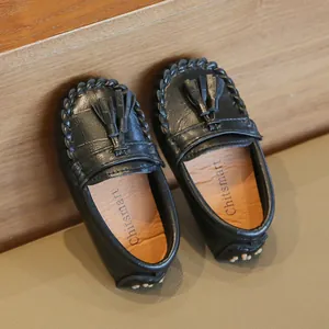 Detail von schwarzen Kinder-Loafers mit Quasten und strukturierter Kunstlederoptik