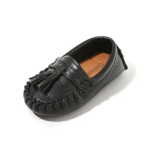 Nahaufnahme der schwarzen Kinder-Loafer mit Krokoprägung, Troddel und brauner Sohle