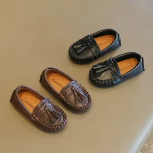 Detailansicht von Kleinkinder-Loafern in Schwarz und Braun mit Quasten-Akzenten.
