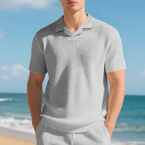 Gros plan d'un polo gris en maille gaufrée pour homme avec un col camp minimaliste.