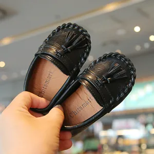Detailansicht schwarzer Kinder-Loafer mit Lederquasten und geflochtenen Kanten.