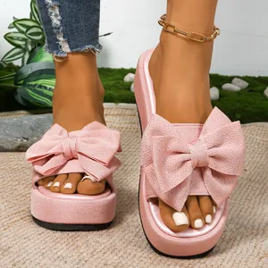 Elegantes sandalias de plataforma rosas con un gran lazo para un estilo playero chic.
