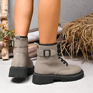 Dettaglio di stivali combat grigi stile britannico con suola platform e fibbia