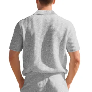 Vue arrière détaillée d'un polo gris en maille gaufrée pour hommes montrant la texture