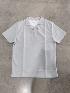 Détail d'un polo gris en maille gaufrée pour homme avec col cranté et texture.