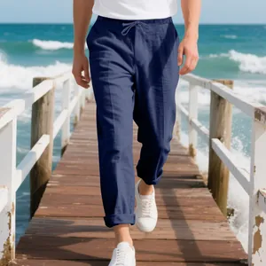 Detail shot of men's loose navy linen beach pants with drawstring waist on pier