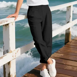 Detailed view of men's loose black linen trousers on a sunny beach pier background