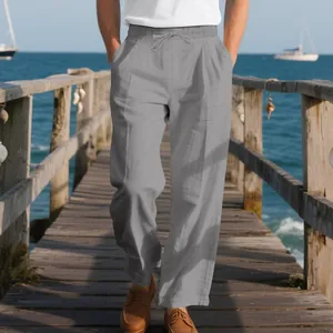 Relaxed fit grey linen trousers for men, styled on a coastal wooden pier background.