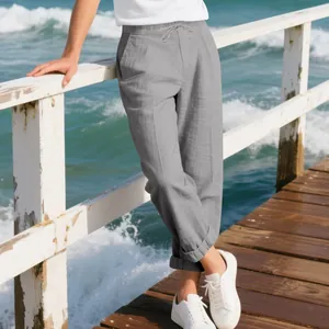 Relaxed fit grey casual linen trousers for men on a sunny wooden pier by the ocean