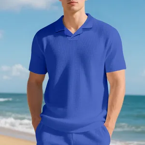 Gros plan détaillé d'un polo bleu en maille gaufrée montrant la texture sur la plage