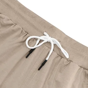 Nahaufnahme des elastischen Bundes mit weißem Kordelzug an einer khakifarbenen Hose.
