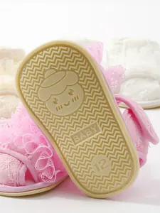 Close-up van de roze babysandaalzool met antislip golfpatroon en het BABY tekstdetail