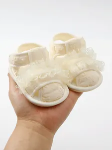 Macro-opname van delicaat borduurwerk op crème babyschoentjes voor kleine kinderen