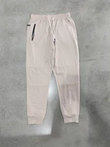 Vista dettagliata dei pantaloni sportivi beige da uomo con coulisse e tasca con cerniera