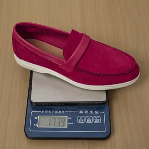 Close-up weight demonstration of a single magenta suede flat loafer showing 173.9g on scale
