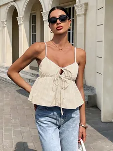 Chic model wearing a yellow striped tie-front camisole top and light blue jeans outdoors