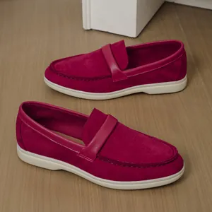 Detailed side view of classic red suede women's flat slip-on loafers on wooden floor