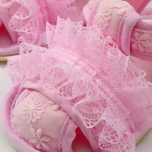 Macrodetail van roze baby kant sandalen met delicaat bloemenborduurwerk voor meisjes