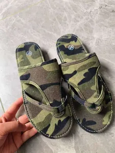 Detailansicht von Camouflage-Leinen-Flip-Flops mit weißen Nähten auf Marmorboden