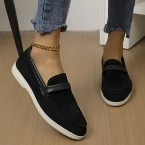 Elegant black suede loafers for women featuring stylish white flat soles and leather strap detail