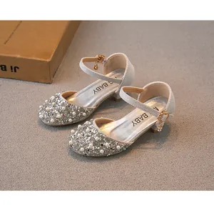 Gros plan de chaussures de princesse argentées pour filles avec sequins et perles