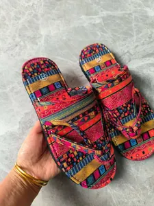 Detailansicht bunter Ethno-Flip-Flops mit Bohemian-Mustern auf einem Marmorboden