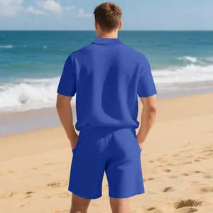 Rear view of a men's casual blue waffle knit polo shirt and shorts set on a sunny beach