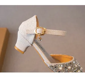 Détail de chaussure princesse argentée pour fille avec strass, perles et boucle à breloque