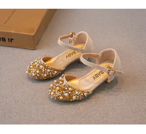 Vue détaillée des chaussures de princesse dorées pour filles avec strass et perles.