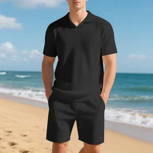 Detailed view of men's black waffle knit polo set with textured fabric on the beach