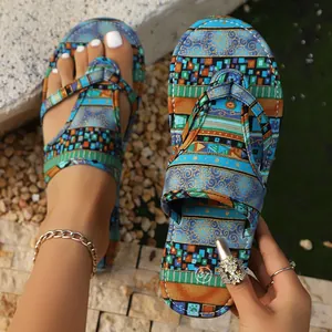 Nahaufnahme von flachen Flip-Flops im Boho-Stil mit buntem Ethno-Muster aus Stoff