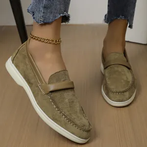 Detailed on-foot view of women's olive green suede slip-on loafers with a gold anklet