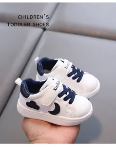 Detailed view of white toddler walking shoes with soft soles and navy moon motifs