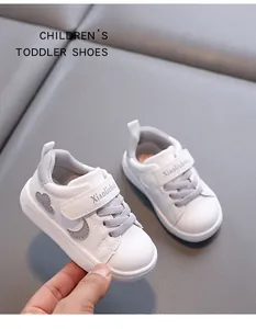 Detailed view of white toddler walking shoes with soft soles and velcro straps