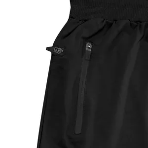 Detailansicht der Reißverschlusstasche und des Bundes einer schwarzen Herren-Jogginghose