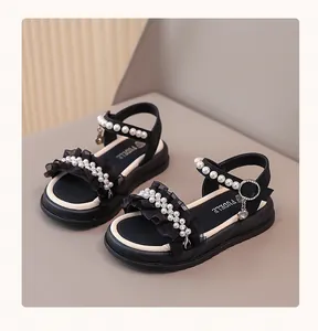Close-up of black girls' princess sandals featuring pearl trim and ruffled lace detail