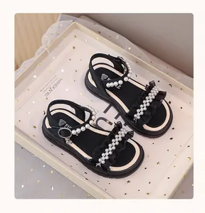 Close-up of girls' black princess sandals with elegant pearl and ruffle details