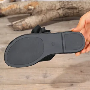 Close-up view showing the non-slip sole texture of women's black flat summer beach slippers