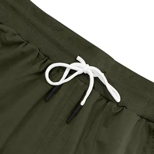 Detaillierte Nahaufnahme einer olivgrünen Herrenhose mit weißem Kordelzug und Rippbund