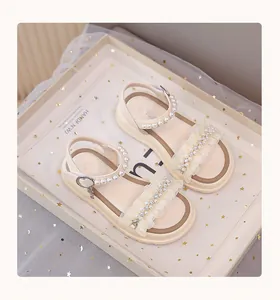 Close-up of elegant girl's princess sandals with decorative pearls and soft lace ruffles
