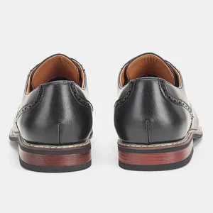 Detaillierte Rückansicht klassischer schwarzer Derby-Lederschuhe mit Brogue-Mustern und Absatz