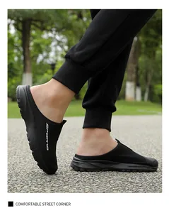 Side view of black breathable mesh slip-on mule sneakers for men in a casual outdoor setting