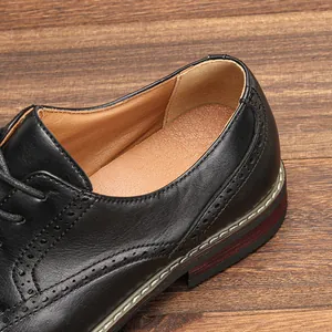 Detailaufnahme schwarzer Herrenschuhe aus Leder mit klassischen Budapester-Verzierungen