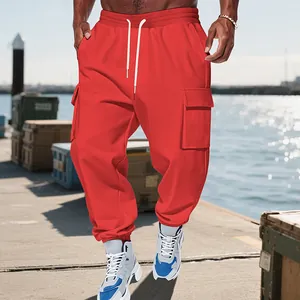 Close-up of red men's heavyweight cargo joggers featuring multiple utility pockets and drawstring