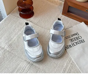 Vista superior de zapatillas Mary Jane plateadas para niñas en fondo beige