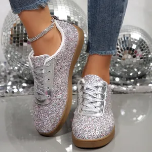 Fashionable shiny silver glitter flat casual sneakers for women with disco ball background
