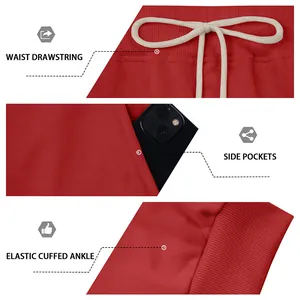 Detail view of red joggers with waist drawstring, side pockets, and cuffed ankles