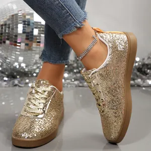 Detail of gold glitter sneakers with sparkling finish and disco ball background