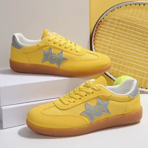 Primer plano detallado de zapatillas casuales amarillas con patrón de estrella y suela